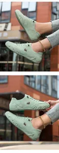 Nahaufnahme hellgrüner Wildleder-Freizeitschuhe mit Tierlogo und handgenähten Details am Rand