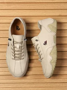 Detalle de zapatos informales de cuero crema con puntas de cordones y logotipo de la marca