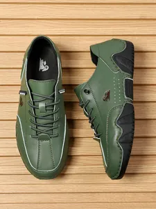 Detalle de zapatos casuales de cuero verde oliva con costuras blancas y logotipo de carnero