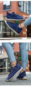 Detail of blue suede casual shoes featuring white hand-stitched seams and gum rubber sole