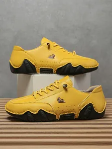 Detalle de zapato casual amarillo mate con logo lateral, hebilla metálica y suela goma