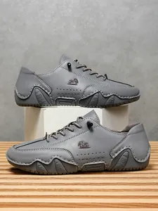 Detalle de zapatos casuales de cuero gris con costuras a mano y orificios de ventilación
