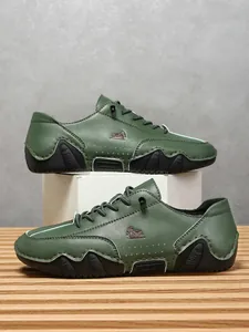 Detalle de zapatos casuales de cuero verde oscuro con logo de carnero y suela ondulada