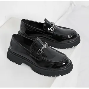 Macro view of black patent leather platform loafer with silver horsebit buckle detail