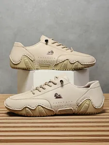 Detalle de zapato casual de cuero beige con diseño perforado y suela de goma ondulada