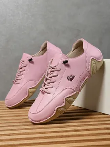 Detalle de calzado casual de cuero rosa con logo de carnero y suela de goma con textura