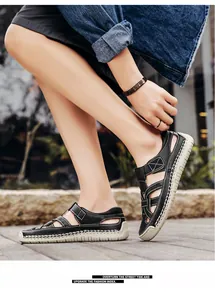Detail of men's black leather outdoor sandals with white stitching and non-slip sole