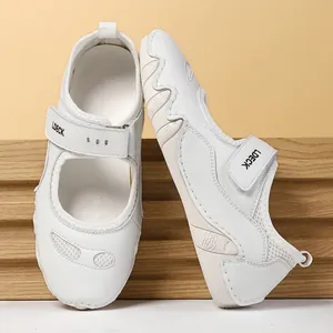 Detalle de zapatos de cuero blanco con cierre de velcro y suela de goma con relieve