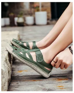 Close-up of green leather outdoor sandals with velcro straps and durable rubber soles