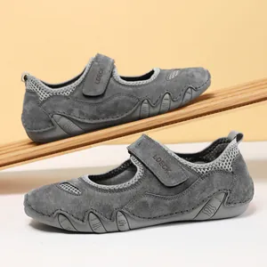 Detalle de zapatos de cuero gris con malla transpirable y cierre de tira adhesiva