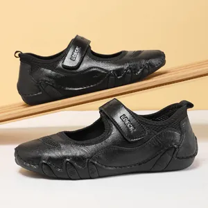 Detalle de zapatos Mary Jane de cuero negro con cierre de velcro y suela de goma