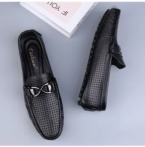Detail van geperforeerde zwarte leren loafers met metalen gesp en een zachte zool