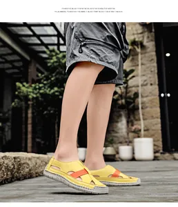 Close-up of yellow woven hollow-out sandals with orange strap and thick rubber sole