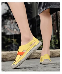 Detailed side view of yellow cut-out sandals with durable grey rubber non-slip soles