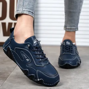 Dettaglio di scarpe casual in pelle blu navy con cuciture bianche e suola in gomma