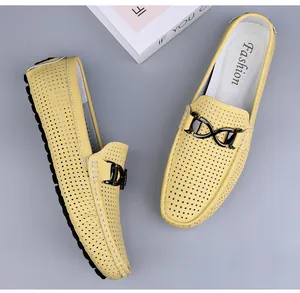 Detail van gele geperforeerde leren loafers met een dubbele metalen gesp op de wreef