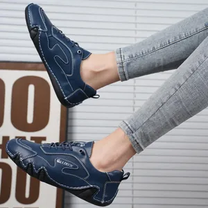 Dettaglio di scarpe casual in pelle blu con cuciture a contrasto e suola in gomma su un modello