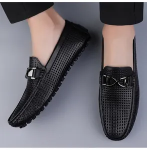 Close-up van zwarte ademende loafers met uitsparingen, metalen gesp en noppenzool