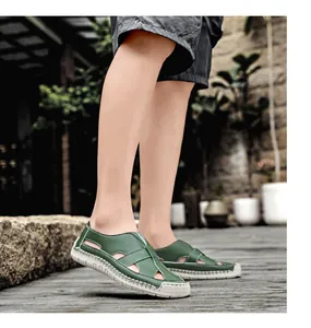 Detailed view of green leather sandals showing hand-stitched 100% rubber sole