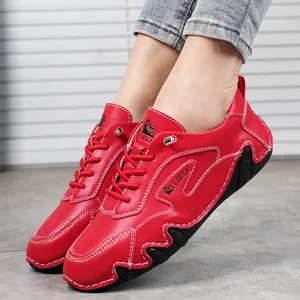 Dettaglio di scarpe casual in pelle rossa con cuciture bianche e suola in gomma ondulata