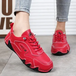 Dettaglio ravvicinato di scarpe casual in pelle rossa con cuciture bianche a contrasto e logo