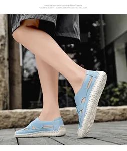 Close-up of light blue hollow-out leather sandals with hand-stitched details and rubber sole
