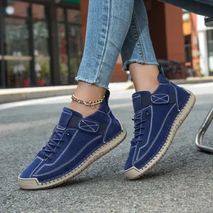 Dark blue suede casual shoes with white stitching and brown rubber sole in a side view