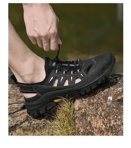 Detail of men's closed-toe outdoor sandals with drawstring lacing on rocky ground