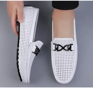 Detail van witte geperforeerde leren loafers met zwarte metalen gesp en zachte rubberen zool