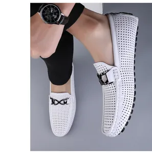 Detail van witte geperforeerde leren loafers met metalen ketting en antislip rubberen zool