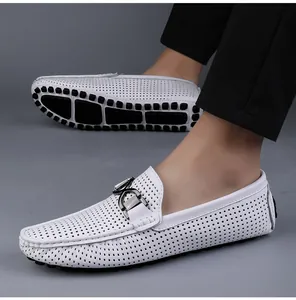 Gedetailleerd zijaanzicht van witte ademende leren loafers met decoratieve metalen gesp