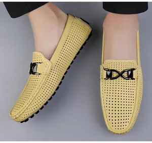 Detail van gele holle lederen loafers met zwarte metalen gesp en ademende perforaties