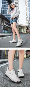 Détail de la couture main sur baskets blanches en cuir avec semelle en gomme marron
