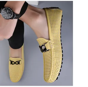 Detail van gele uitgesneden lederen loafers met ademende gaten en stijlvolle metalen gesp