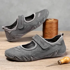 Zapatos casuales de nubuck gris con velcro y detalles de malla en mesa de madera