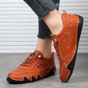 Dettaglio di scarpe in pelle arancione con cuciture bianche e suola in gomma antiscivolo