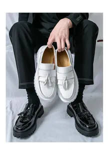 Gros plan de mocassins à franges noir et blanc avec finition vernie et semelles compensées