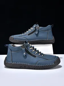 Detail shot of men's matte blue leather ankle boots with hand-stitched seam details