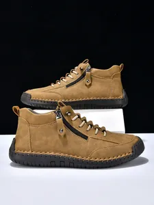 Detailed view of camel leather men's boots featuring side zipper and hand-stitched rubber soles