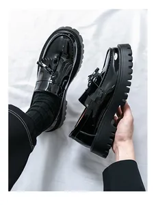 Détails des mocassins noirs à plateforme en cuir verni avec franges et nœud décoratif