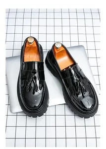 Détail de mocassins à glands en cuir verni noir avec semelles crantées épaisses