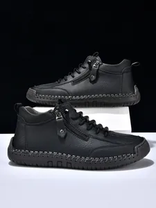 Detail view of black men's ankle boots showing side zipper and contrast stitching
