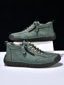Detail of men's high-top martin boots with side zipper, suede upper and contrast stitching