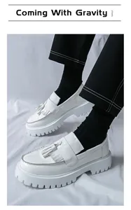 Gros plan sur des mocassins à plateforme en cuir verni blanc avec glands