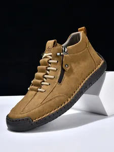 Detail of tan leather boots showing handmade stitching and 100% caoutchouc toe cap