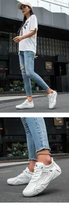Close-up of white outdoor sneakers featuring breathable mesh and leather horse logo detail