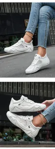 Close-up of white breathable mesh sneakers with leather panels and wave-patterned soles