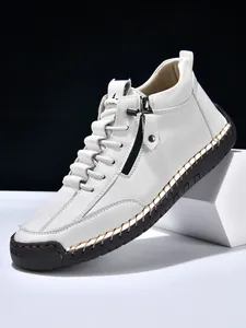 Close-up of white leather high-top boot featuring contrast stitching and side metal zipper