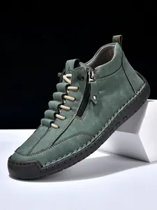 Macro detail of men's leather boot showing contrast stitching and rubber sole branding