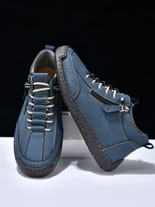 Detail view of blue matte leather boots with side zipper and rugged stitching craft